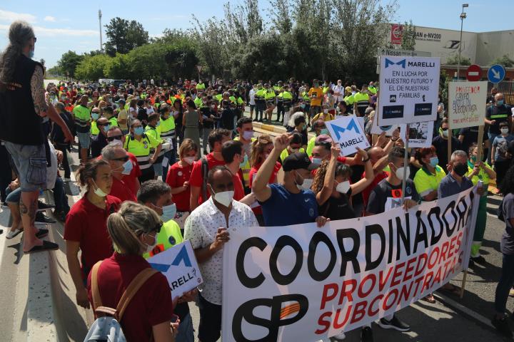 Pla general dels treballadors de Nissan tallant el carrer 3 de la Zona Franca, just davant l'entrada principal de la fàbrica. ACN