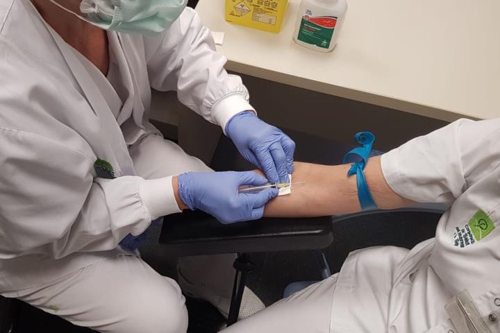 Pla general d'un personal santiari extraient sang a un treballador per fer un test ràpid el 24 d'abril de 2020. ACN