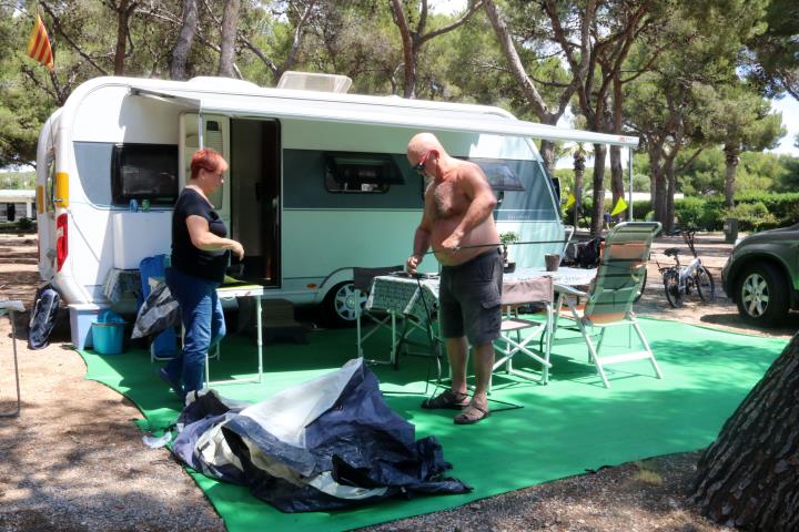 Pla general d'una família desplegant el tendal de la seva autocaravana en l'arribada a un càmping de Sitges, el 12 de juny del 2020. ACN