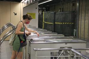 Pla general d'una passatgera validant el seu bitllet de metro a l'estació de Sants de Barcelona. ACN