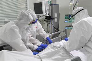 Pla mig dels sanitaris amb un pacient a la UCI de l'Hospital de Manresa (Althaia). Imatge del 24 d'abril de 2020. ACN