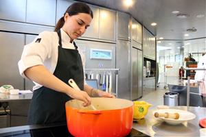 Pla mig d'una de les cuineres d'Alicia't preparant un plat de fideus a la cassola. ACN