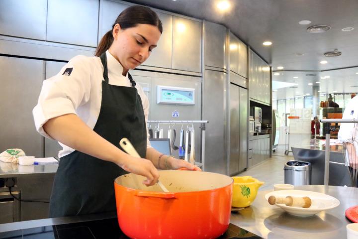 Pla mig d'una de les cuineres d'Alicia't preparant un plat de fideus a la cassola. ACN