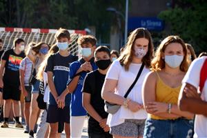 Pla mitjà d'alumnes de 4t d'ESO de l'institut Martí i Franquès de Tarragona en filera i amb mascareta durant la presentació al pati el 14 de setembre 