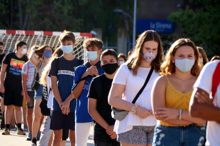 Pla mitjà d'alumnes de 4t d'ESO de l'institut Martí i Franquès de Tarragona en filera i amb mascareta durant la presentació al pati el 14 de setembre 