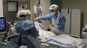 Pla mitjà de dues infermeres atenent una pacient de covid-19 ingressada al servei de Medicina Intensiva de l'Hospital de Tortosa Verge de la Cinta. Ho