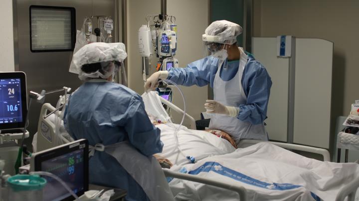 Pla mitjà de dues infermeres atenent una pacient de covid-19 ingressada al servei de Medicina Intensiva de l'Hospital de Tortosa Verge de la Cinta. Ho