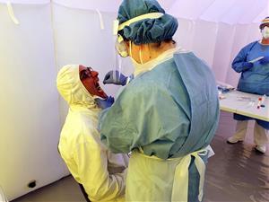 Pla mitjà d'una infermera prenent mostres per la prova PCR de detecció de la covid a un empleat de Padesa a Roquetes. Salut