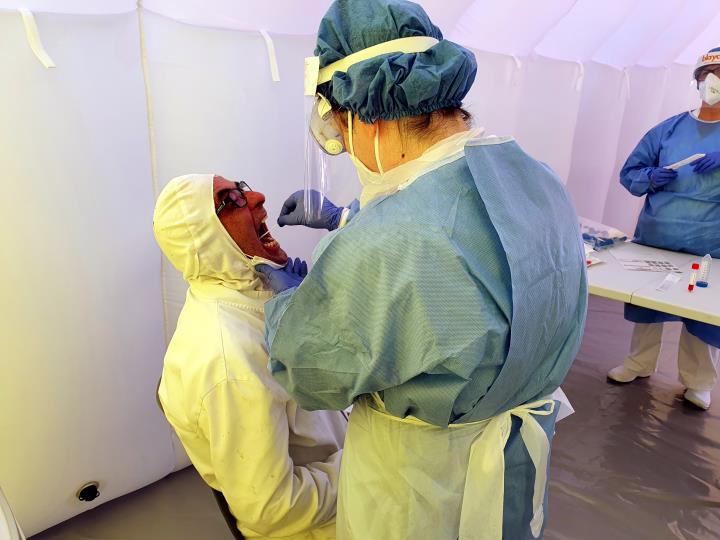 Pla mitjà d'una infermera prenent mostres per la prova PCR de detecció de la covid a un empleat de Padesa a Roquetes. Salut