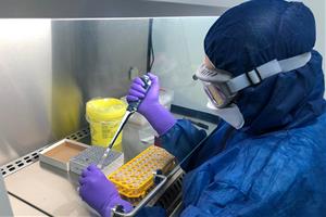 Pla mitjà d'una treballadora analitzant una mostra de PCR en el laboratori d'Hipra el 8 d'abril de 2020. ICS Girona
