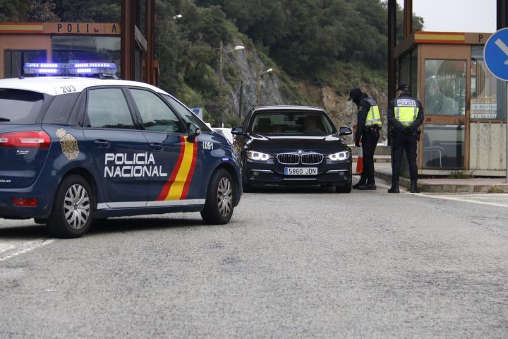 Pla obert de dos agents de la Policia Nacional fent un control en un turisme espanyol que vol creuar la frontera al Pertús el 17 de març de 2020. ACN