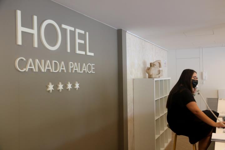 Pla obert de la recepció d'un hotel, amb una treballadora atenent el telèfon amb mascareta. Imatge del 9 de juliol del 2020 . ACN
