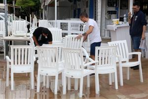 Pla obert dels treballadors d'un restaurant netejant les taules i cadires per reobrir l'establiment