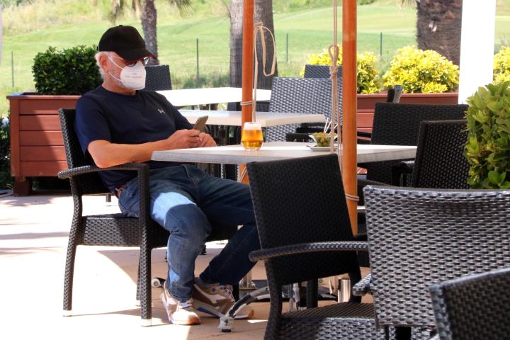 Pla obert d'un client en una terrassa de Sitges, amb mascareta, prenent una cervesa el primer dia de la fase 1 del desconfinament. ACN