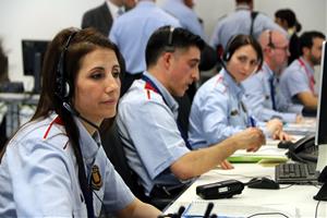Primer pla d'una agent dels Mossos d'Esquadra, amb auriculars i micròfon, atenent incidents policials a la sala de comandament del 112 de Reus. ACN