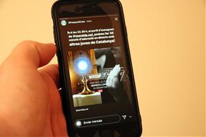 Un mòbil mostra un missatge d'Instagram que convida a pregar durant la setmana santa el 10 d'abril del 2020. ACN