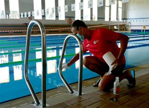 Un operari preparant la piscina municipal del Vendrell. Eix