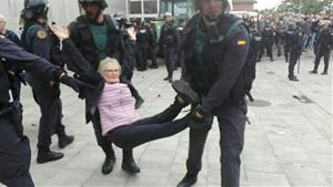 Una àvia es portada a braços per agents de la Guàrdia Civil en el desallotjament del col·legi electoral de la Ràpita. ACN
