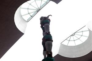 Una enxaneta fa l'aleta amb el sostre a prop en el Concurs de Castells de Tarragona 2016. ACN