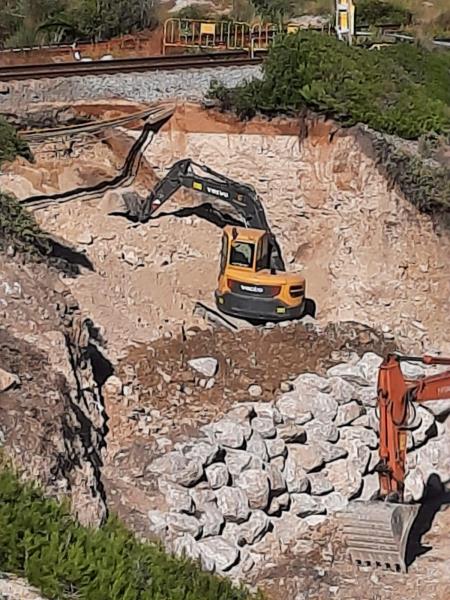 Una excavadora treballa per reparar un esvoranc al tram Vilanova-Sitges de la línia de Rodalies de Renfe R2 sud el 12 d'octubre del 2020. Renfe