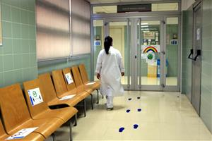 Una infermera del CAP Verdaguer camina cap a l'àrea reservada a l'atenció pediàtrica, zona aïllada, amb un dibuix de l'arc de Sant Martí. ACN
