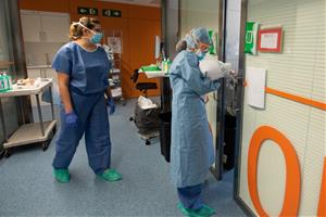 Una professional sanitària entra en una habitació ocupada per un positiu per coronavirus a l'Hospital Clínic