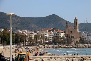 Gran pla general de la platja de Sitges amb nombroses persones prenent el sol el 28 de març del 2021. ACN