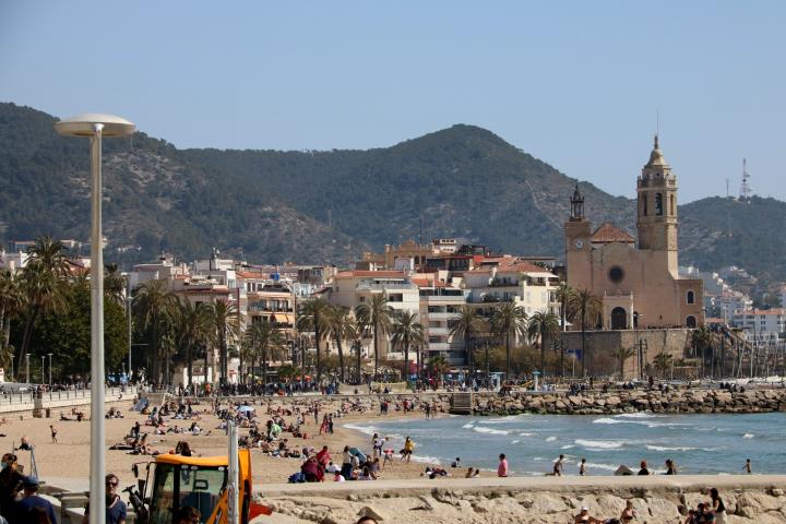 Gran pla general de la platja de Sitges amb nombroses persones prenent el sol el 28 de març del 2021. ACN
