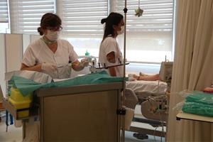 Imatge de dues infermeres atenent un nen fent tractament a l'Hospital de Dia de Vall d'Hebron. ACN