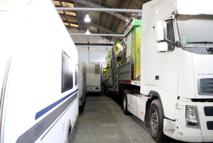 Imatge d'una atracció carregada en un camió i una caravana a la nau del Gremi de Firaires de Barcelona a Martorell. ACN