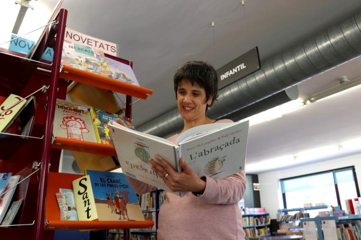 Pla general de la bibliotecària de Banyoles llegint un llibre infantil el 17 d'abril de 2021. ACN