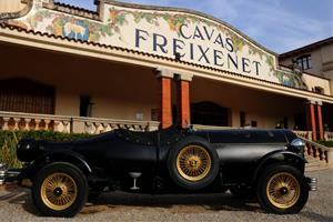 Pla general de la façana principal de les caves Freixenet, a Sant Sadurní d'Anoia, amb un vehicle amb forma d'ampolla en primer terme. ACN