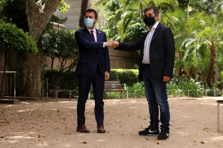 Pla general dels dirigents d'ERC i de Junts, Pere Aragonès i Jordi Sànchez, xocant els punys per celebrar l'acord de govern de coalició el 17 de maig 