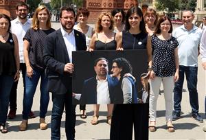 Pla mitjà de Pere Aragonès i Marta Vilalta amb una foto d'Oriol Junqueras i Marta Rovira. ACN