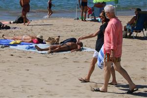 Pla obert de dos banyistes arribant a la platja amb mascareta. Imatge del 3 de setembre del 2020. ACN