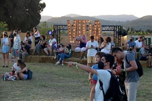 Públic del festival Vida a la Masia d'en Cabanyes amb les lletres de fons, l'1 de juliol del 2021. ACN