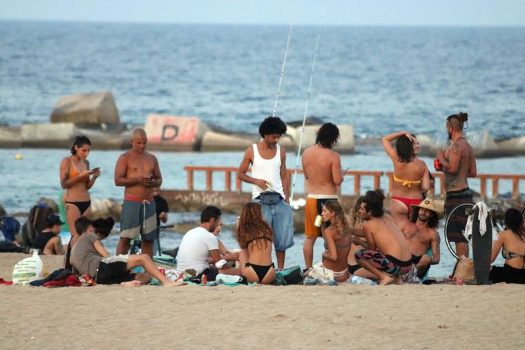 Un grup de persones fan el 'botellón' a la platja de la Barceloneta de Barcelona el 28 de juliol del 2020 abans de les 12 hores de la nit. ACN