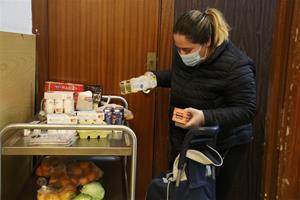 Una dona omple un carro de menjar a un punt de distribució d'aliments de Cáritas. ACN