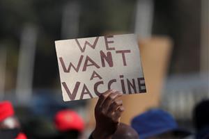 Una persona amb un cartell que reclama accés a les vacunes contra la COVID-19, a Pretòria, Sud-àfrica, el 25 de juny de 2021. REUTERS / Siphiwe Sibeko