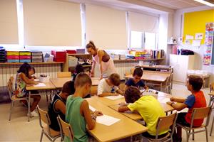 Alumnes de segon de primària durant l'hora de lleure educatiu, amb una de les monitores. ACN / Laura Cortés