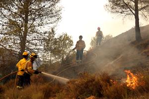 Bombers apaguen el foc a primera línia al Pont de Vilomara i Rocafort . ACN / Nia Escolà