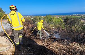 Dos voluntaris de l’ADF remullant una zona cremada per evitar possibles revifades. ADF Penedès-Garraf