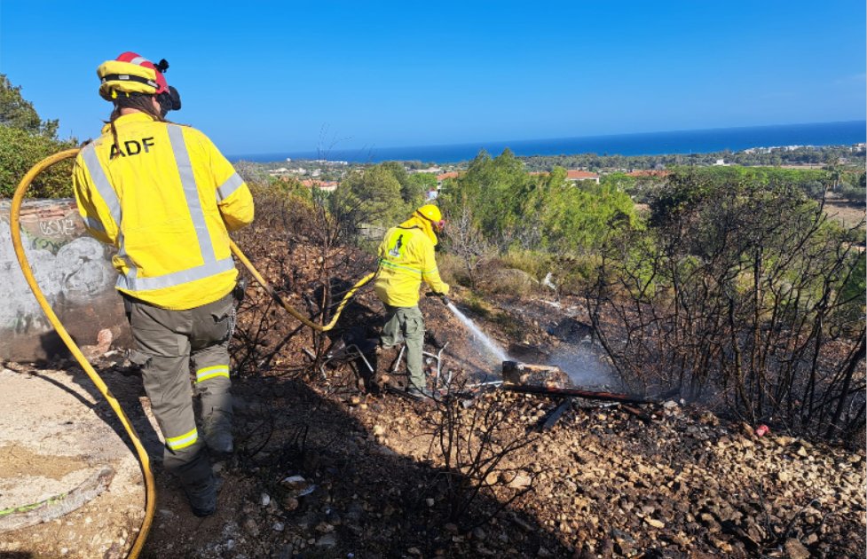 Dos voluntaris de l’ADF remullant una zona cremada per evitar possibles revifades. ADF Penedès-Garraf