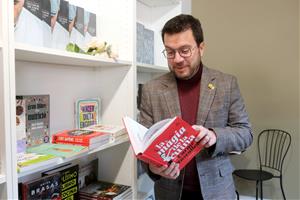 El president de la Generalitat, Pere Aragonès, fullejant un llibre en una llibreria. ACN / Xavier Pi