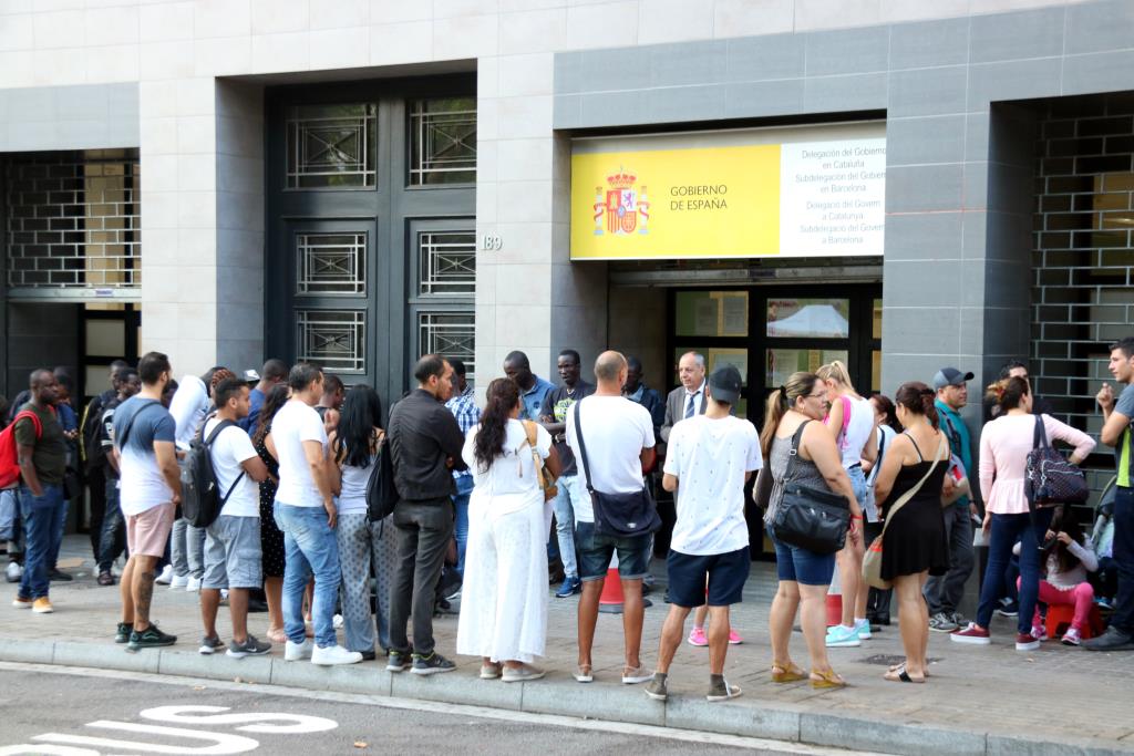 Desenes de persones fan cua a les portes de l'Oficina d'Estrangeria del Passeig de Sant Joan. ACN / Miquel Codolar