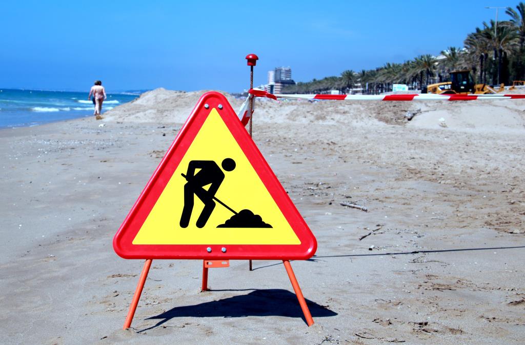 Senyal d'obres a la platja de Calafell per indicar que s'està treballant en el traspàs de sorra. ACN / Mar Rovira