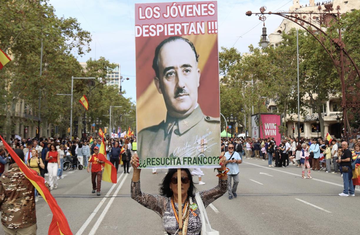 Una dona amb un cartell amb el rostre de Franco a la manifestació pel 12-O a Barcelona . ACN / Nico Tomas