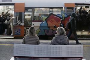 Dues usuàries de Rodalies assegudes a un banc a l'estació . ACN / Jordi Pujolar