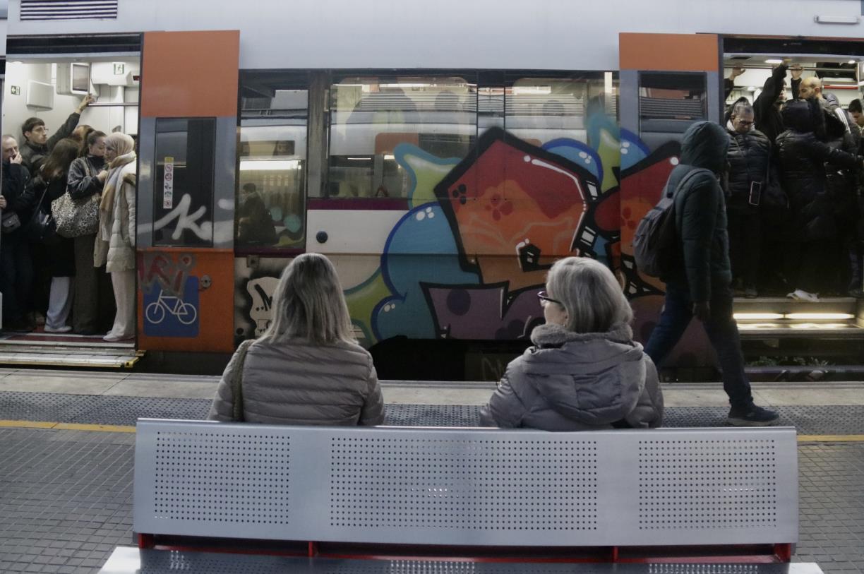 Dues usuàries de Rodalies assegudes a un banc a l'estació . ACN / Jordi Pujolar
