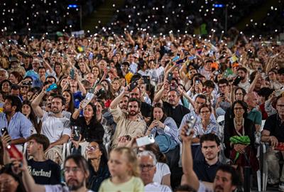 Fidels aixecant les llanternes del mòbil en la part final de la vetlla del papa Lleó XIV a l'Estadi Olímpic . ACN / Jordi Borràs